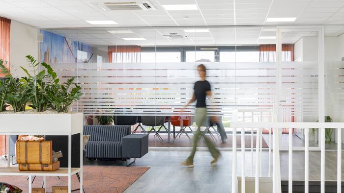 Lounge met planten en een collega die voorbijloopt